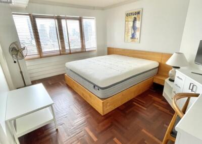 Modern bedroom with large window, wooden floor, and simple furniture