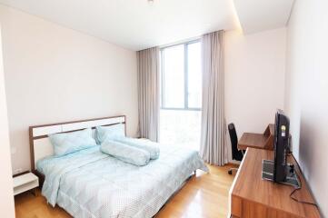 Modern bedroom with a large window, bed, and desk