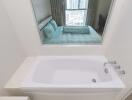 Bathroom with bathtub and window overlooking bedroom