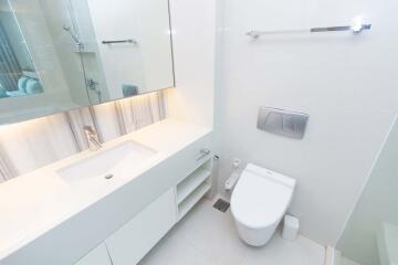 Modern bathroom with white fixtures and large mirror