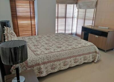 Well-lit bedroom with large windows and floral bedspread