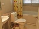 Well-lit bathroom with bathtub and Hello Kitty curtain