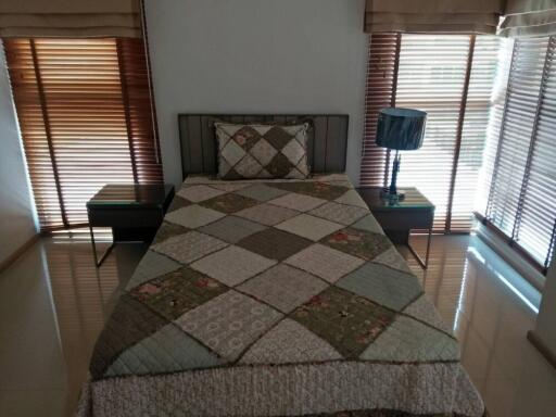 Cozy bedroom with a single bed, patterned quilt, and wooden blinds