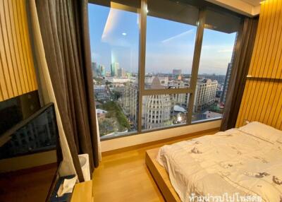 Modern bedroom with a large window offering a cityscape view