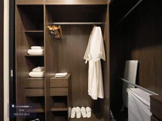 Well-organized walk-in closet with wooden shelves and hanging area