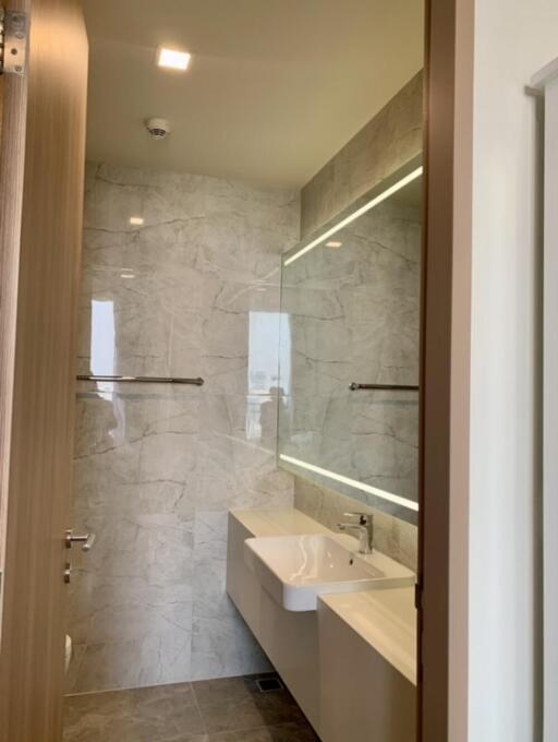 Modern bathroom with marble tiles and large mirror