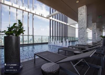 Rooftop pool area with lounge chairs and city view