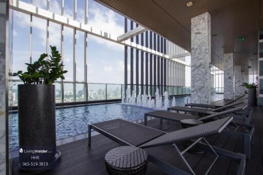 Rooftop pool area with lounge chairs and city view