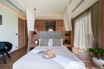 Well-lit bedroom with wooden accents and large windows