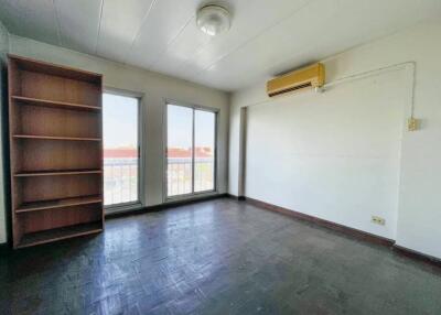 Spacious bedroom with large windows and built-in bookshelf