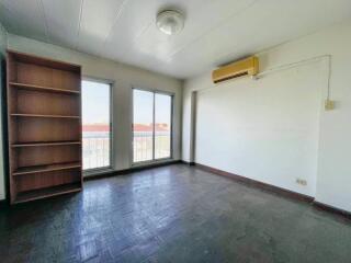 Spacious bedroom with large windows and built-in bookshelf