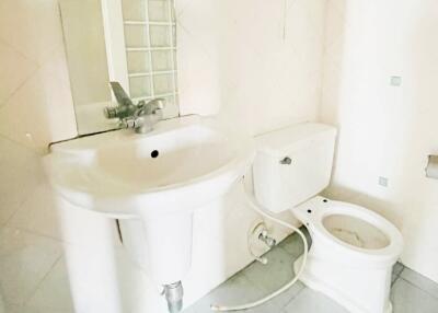 White bathroom with sink, toilet, and wall-mounted fan