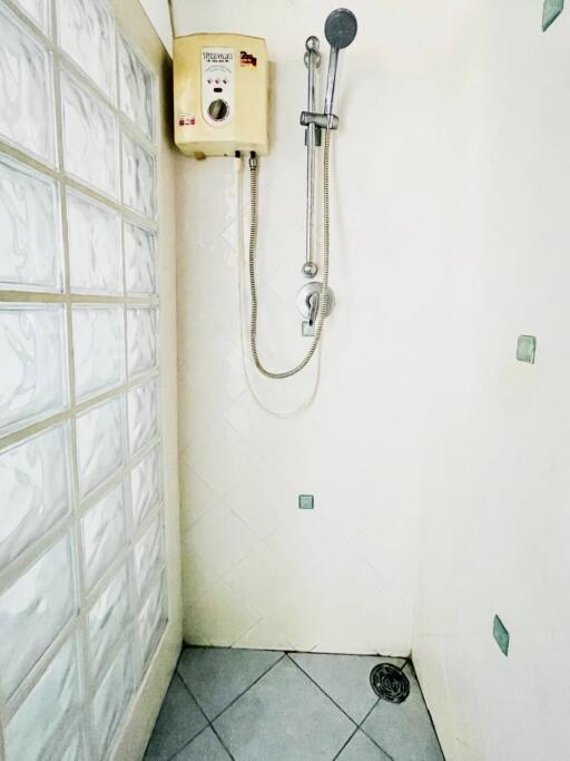 Shower area with tile flooring and water heater