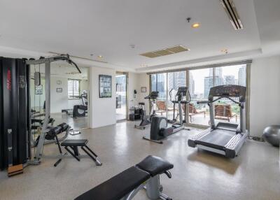 Spacious gym with various workout equipment and city view