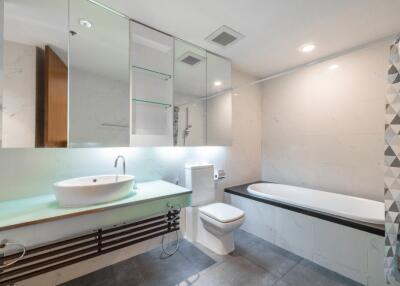 Modern bathroom with glass cabinetry, bathtub, and stylish sink