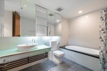 Modern bathroom with glass cabinetry, bathtub, and stylish sink