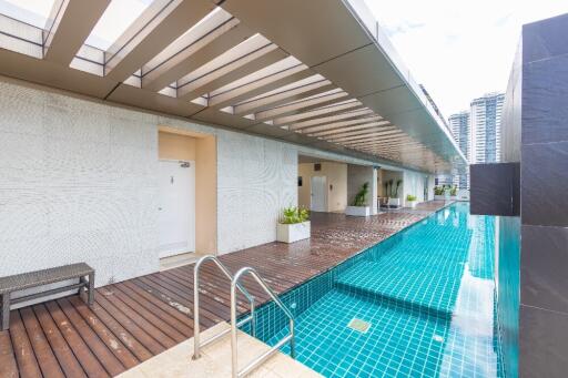 Outdoor pool area with adjacent walkway and seating