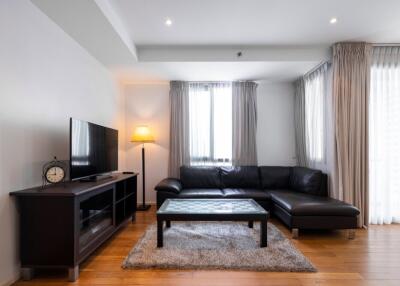 Modern living room with sectional sofa, coffee table, TV unit, and floor lamp