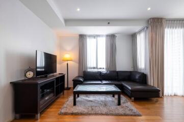 Modern living room with sectional sofa, coffee table, TV unit, and floor lamp