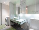 Modern bathroom with sink, mirror, toilet, and washing machine