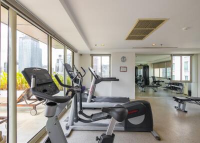 Modern gym with various exercise equipment and large windows