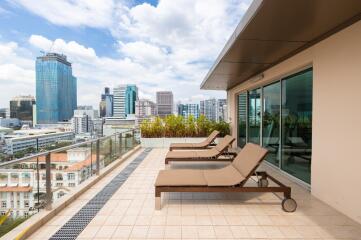 Spacious balcony with city view and lounge chairs