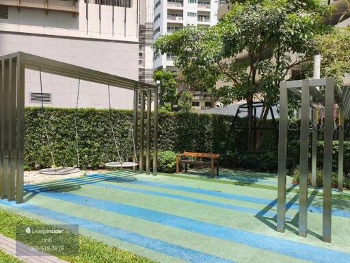 Playground with metal structures including swings and a bench