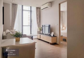 Modern living room with large window, air conditioner, and adjacent bedroom