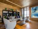 Modern living room with wooden floor, large windows, a bookshelf, and comfortable seating