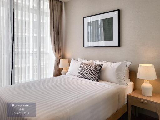 Well-lit bedroom with a double bed, bedside tables, and lamps