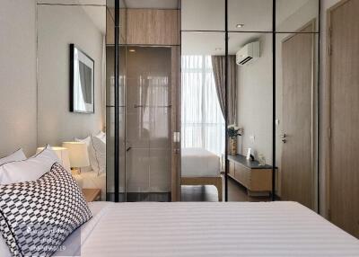 Modern bedroom with mirrored wardrobe doors, bed, checkered cushions, and ambient lighting