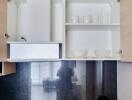 Modern kitchen with open cupboards showing crockery and a kettle on the countertop