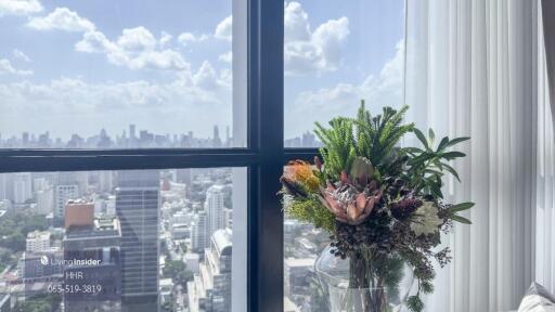 Skyline view from living area with large window and floral arrangement