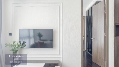 Living room with wall-mounted TV and plant decor