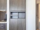 Modern kitchen with wooden cabinets and visible bathroom entrance