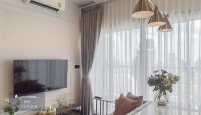 Living room with a television, air conditioning, coffee table, curtains, and decorative lighting