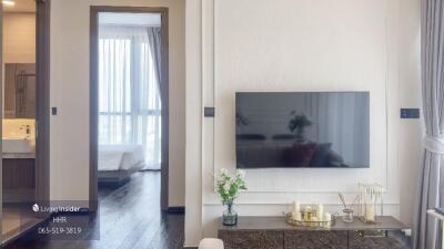 Modern living room with TV and view into a bedroom