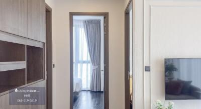 Hallway leading to a bedroom with partial living room view