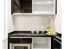 Modern kitchen with black and white cabinets, stove, microwave, and shelves