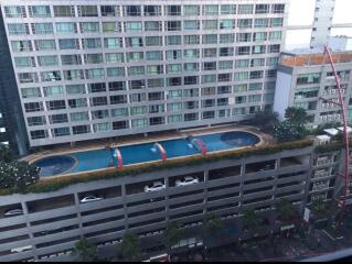 High-rise residential building with a swimming pool and parking area