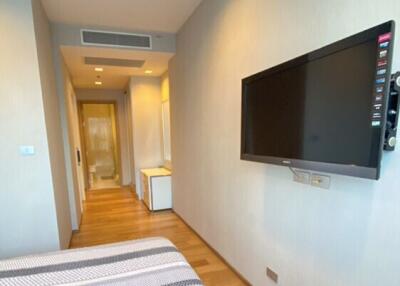 Modern bedroom with wall-mounted TV and hardwood flooring