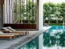 Outdoor pool area with lounge chairs and trees