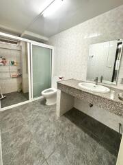 Modern bathroom with granite countertop and glass-enclosed shower