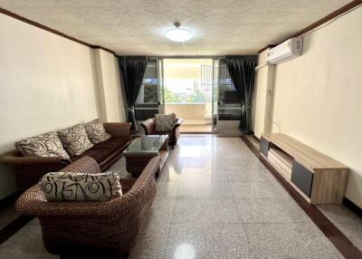 Spacious and well-lit living room with comfortable seating and modern amenities