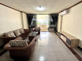 Spacious and well-lit living room with comfortable seating and modern amenities