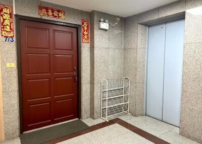 Building entrance lobby with a red door and elevator