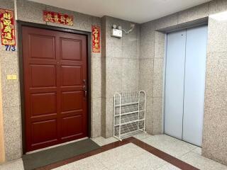 Building entrance lobby with a red door and elevator