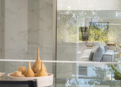 View of a modern living room through a reflective glass wall with light decor