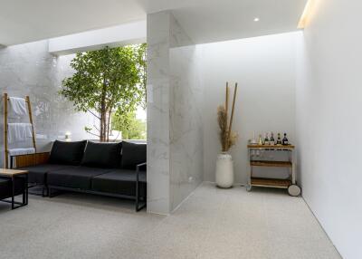 Modern living room with a couch, indoor plant, and beverage cart