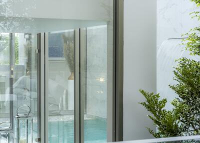 Indoor pool with glass walls and greenery